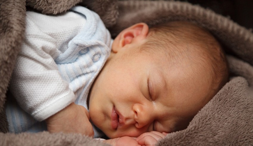 A baby sleeping on a blanket.