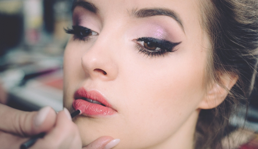 A woman getting her makeup done by a makeup artist.