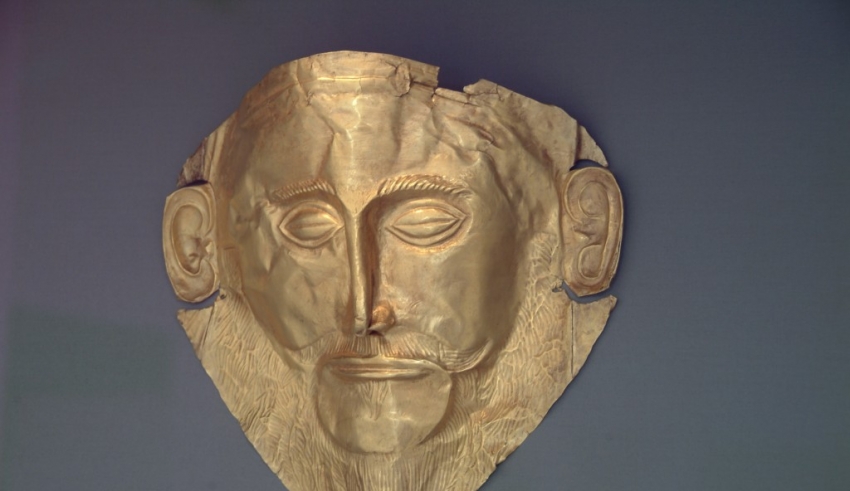 A gold mask on display in a museum.