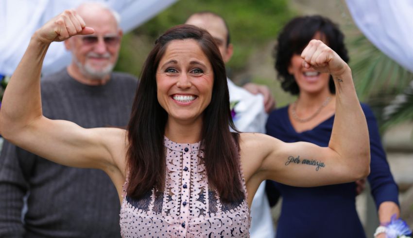 A woman is flexing her muscles in front of a group of people.