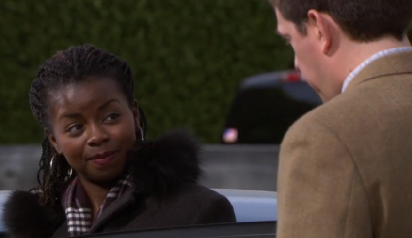 A woman talking to a man in a car.