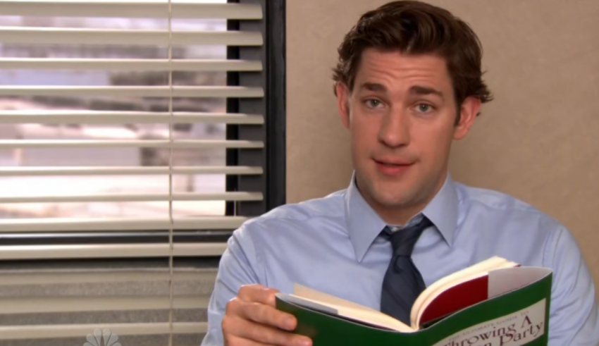 A man reading a book in an office.