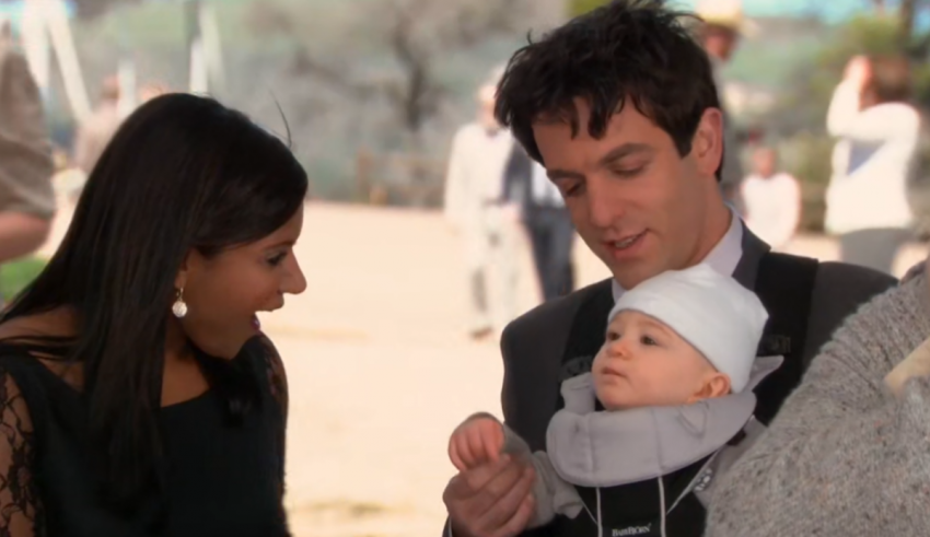A man and woman holding a baby in a stroller.