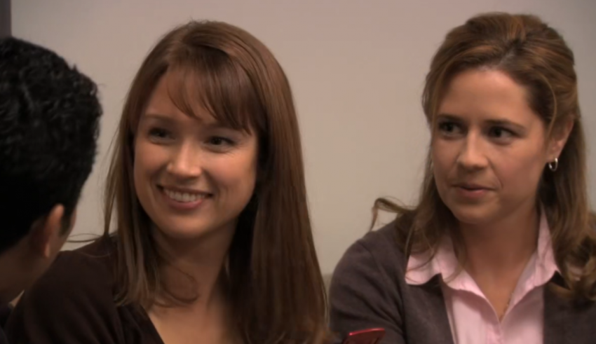 Three women are talking to each other in an office.