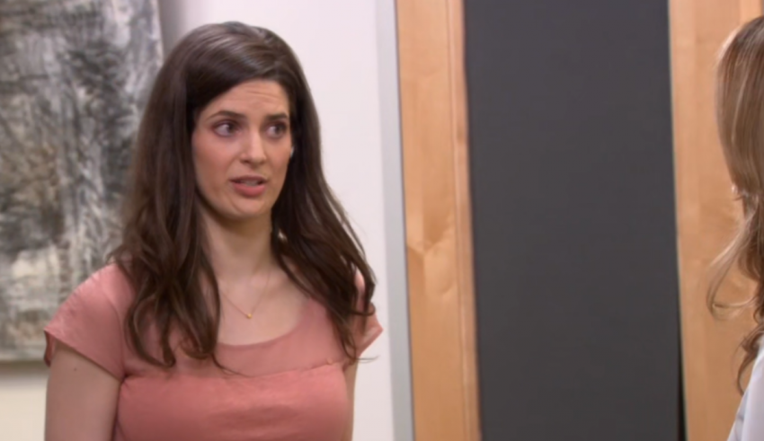 A woman is talking to another woman in an office.
