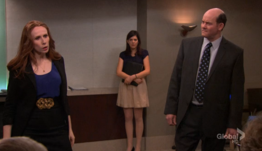 A woman in a business suit standing next to a man in a suit.