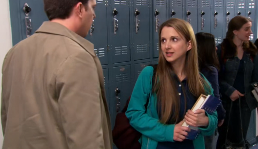 A man and a woman talking in a locker room.