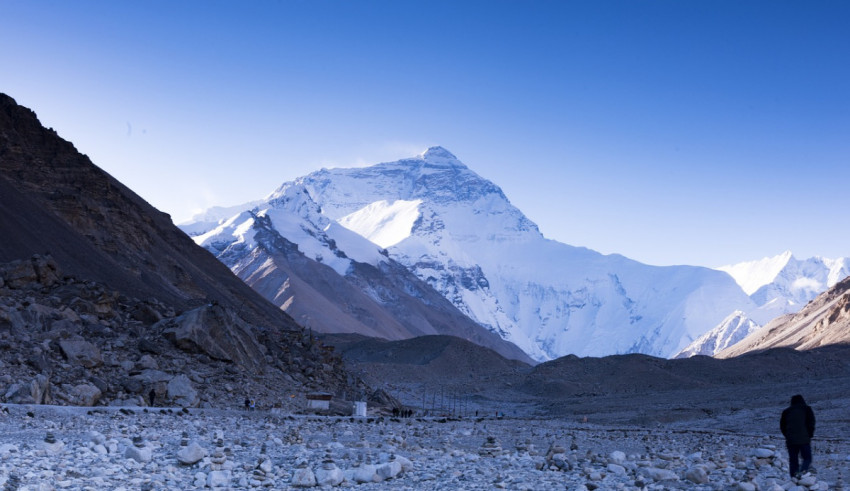 A man is standing in front of a mountain.