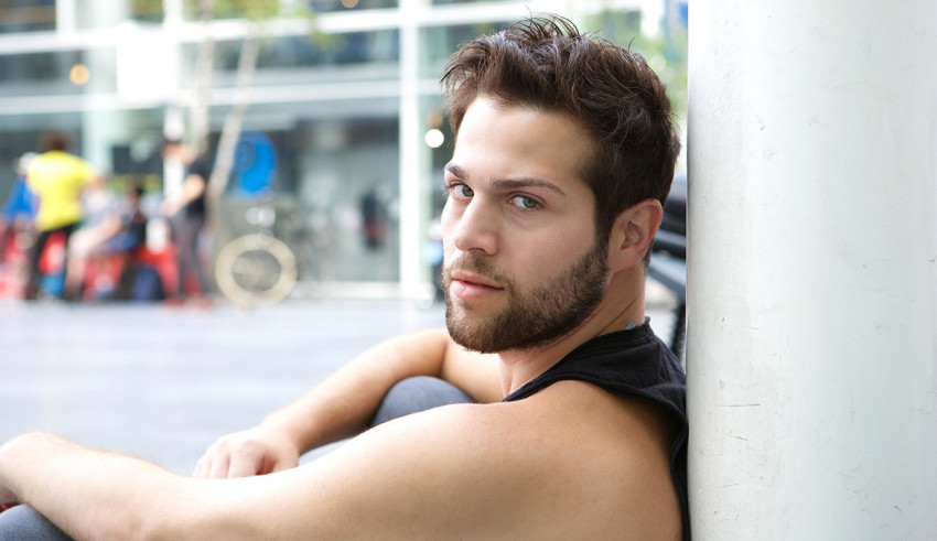 A man leaning against a pillar.