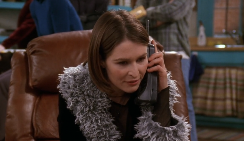 A woman talking on a phone while sitting in a chair.