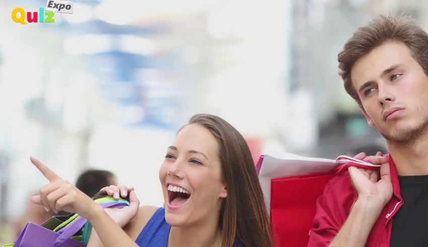 A man and a woman holding shopping bags in a mall.