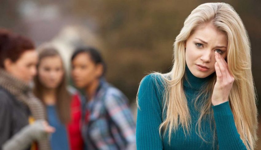 A woman with a headache in front of a group of girls.