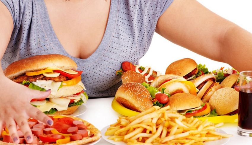 A woman eats a burger and fries.