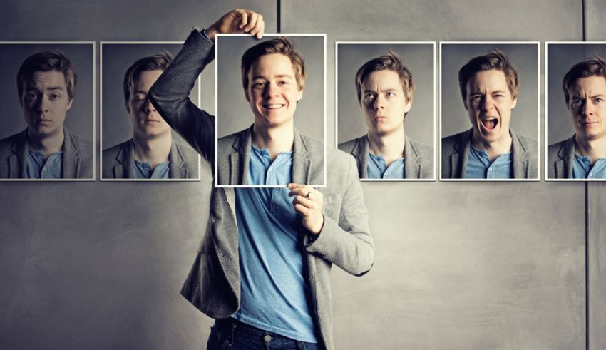 A man holding up a collage of faces.