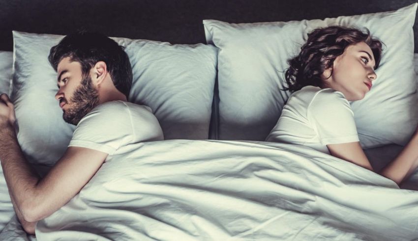 A man and woman laying in bed together.