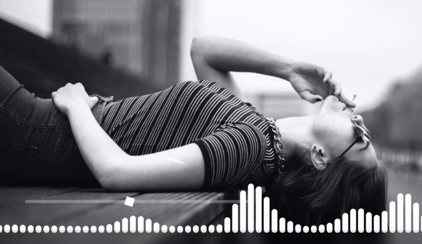 A woman laying on the ground with a sound wave in the background.