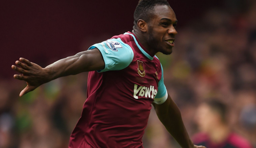 A man in maroon is running with his arms out.