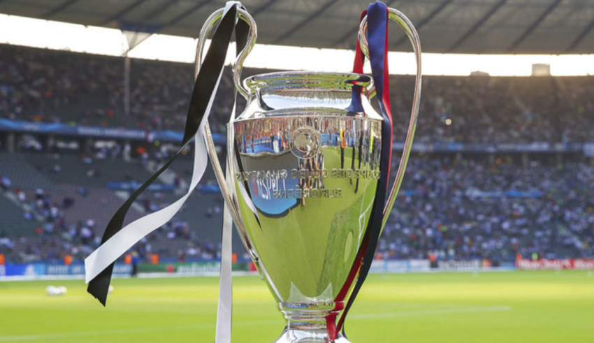The uefa champions league trophy sits on top of a stadium.
