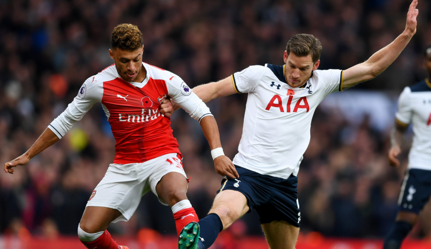 Two soccer players are fighting for the ball.