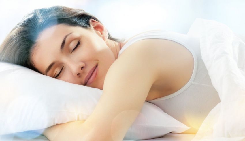 A woman is sleeping in bed with her eyes closed.