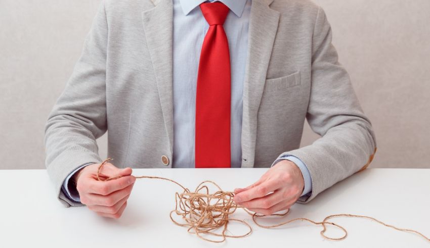 A man in a suit is holding a bundle of string.