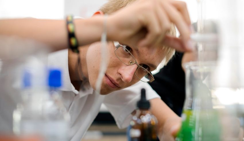 A young man working in a laboratory with a beaker.