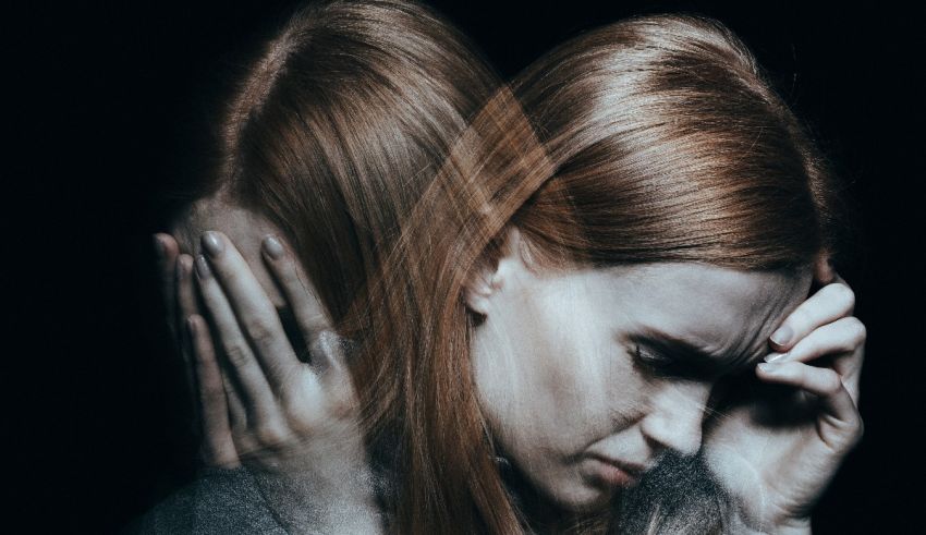 A woman with red hair is holding her head in her hands.