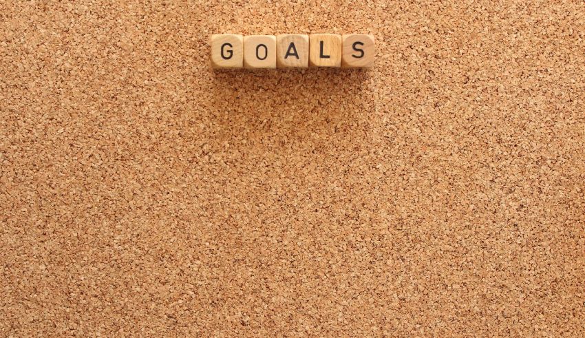 A cork board with the word goals written on it.