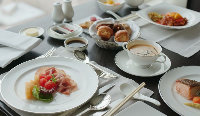 A table with plates, cups, and utensils on it.