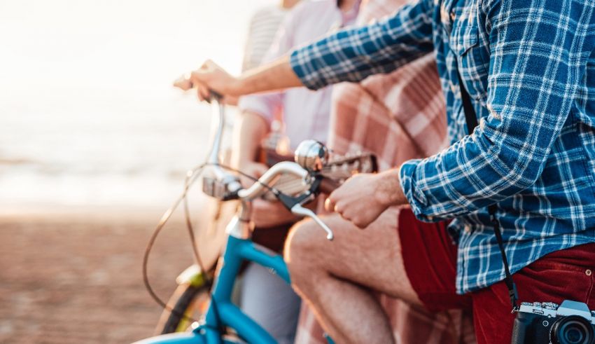 A group of people on a bicycle on the beach.