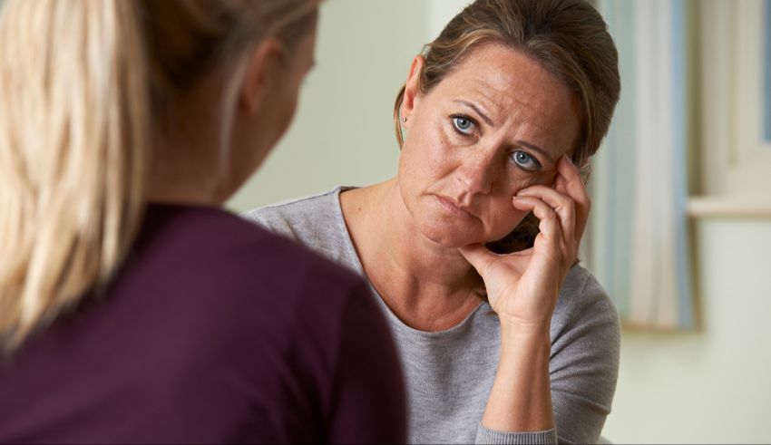 A woman is talking to another woman in a room.