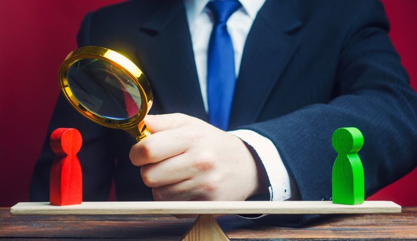 A businessman holding a magnifying glass on a scale.