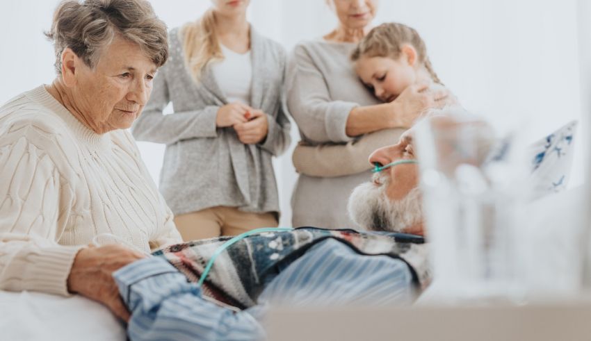 A family is laying in a hospital bed with an elderly man.