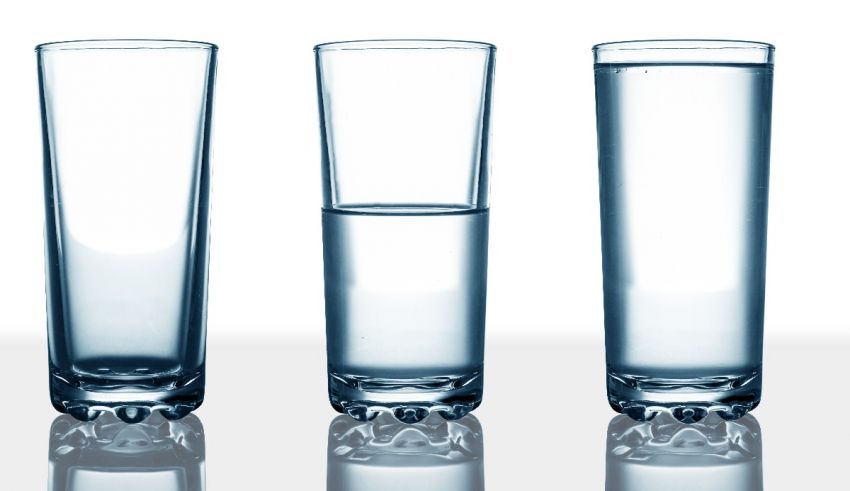 Three glasses of water on a white surface.