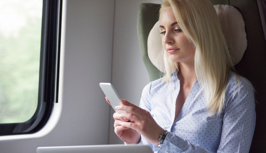 A woman sitting on a train looking at her phone.