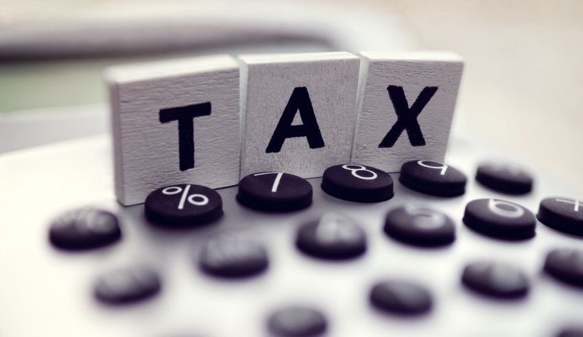 The word tax is written on a calculator.