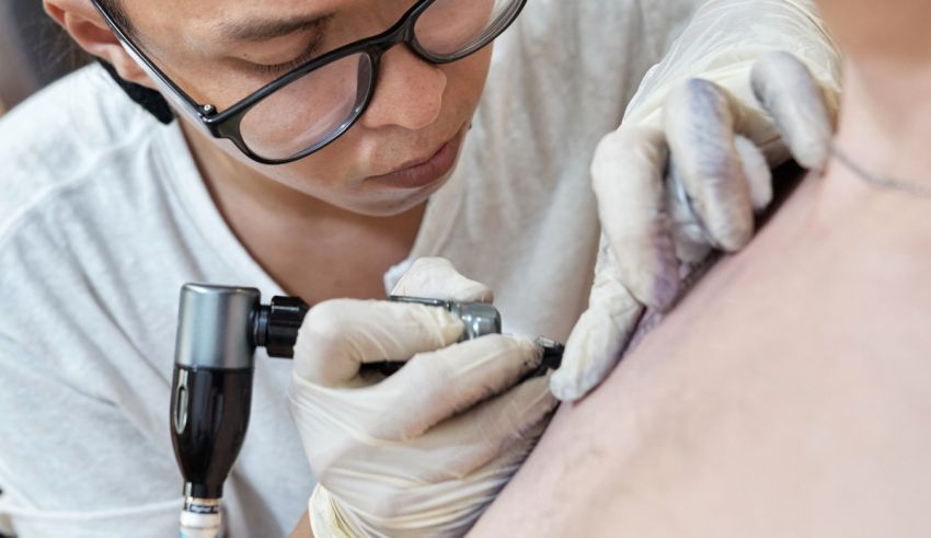 A man is getting a tattoo on his chest.