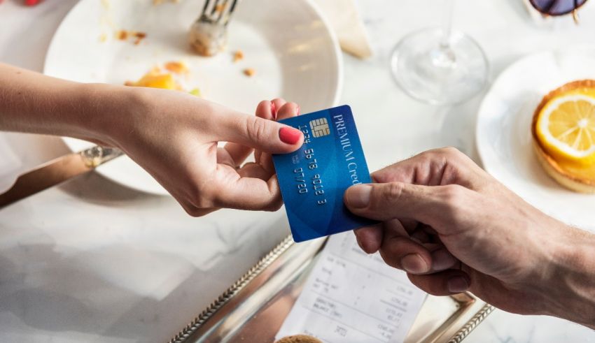 A person is handing a credit card to another person.