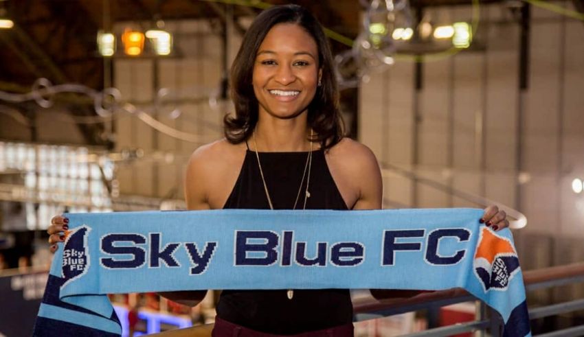 A woman holding a scarf that says sky blue fc.