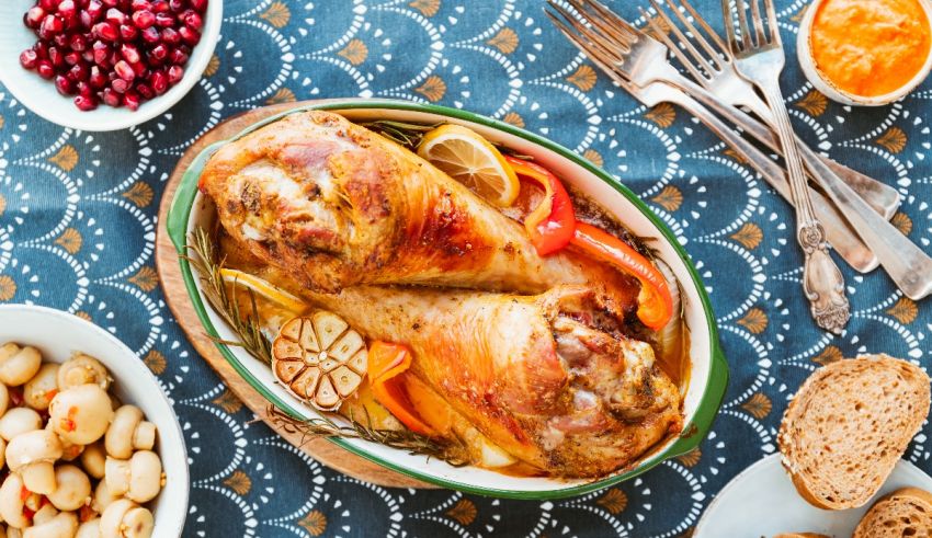 Roasted chicken with pomegranate and bread on a table.