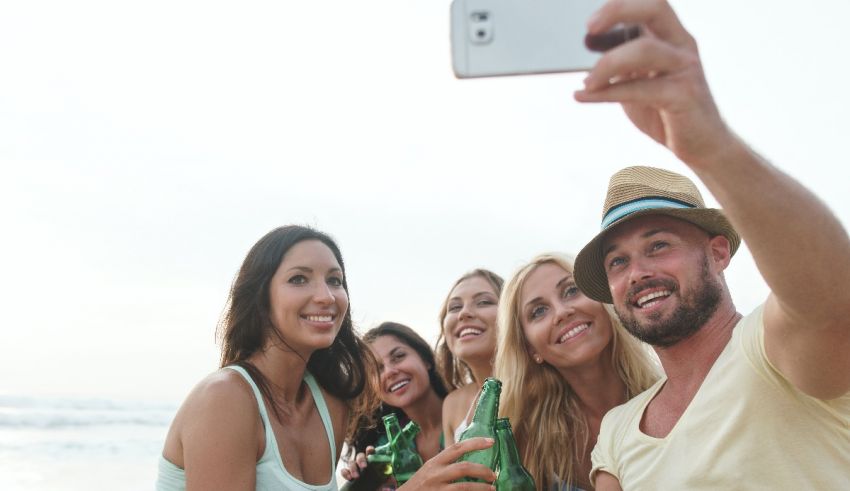 A group of friends taking a selfie on the beach.