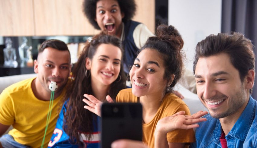 A group of friends taking a selfie while sitting on a couch.