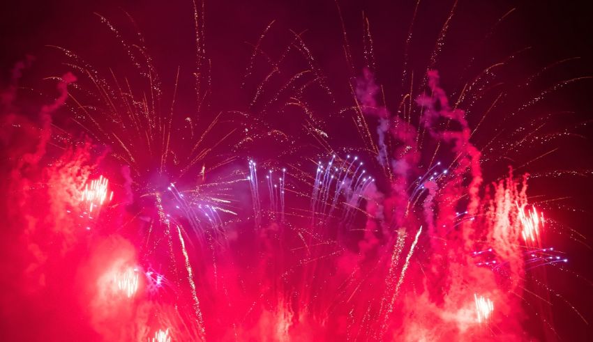A red and blue fireworks display in the night sky.