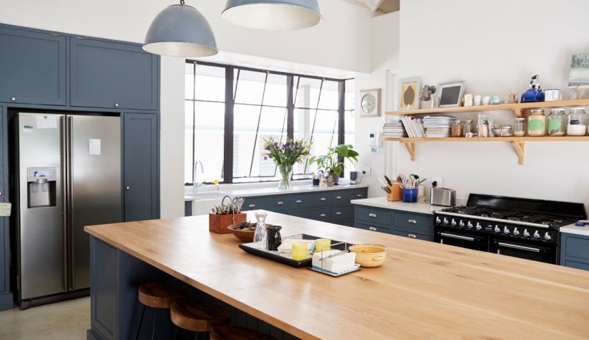 A kitchen with blue cabinets and wooden counter tops.