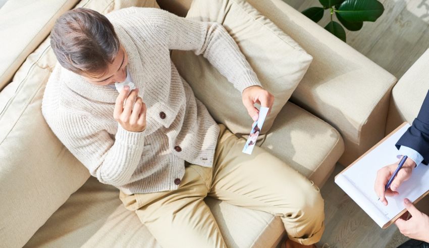 A man is sitting on a couch while a doctor is talking to him.