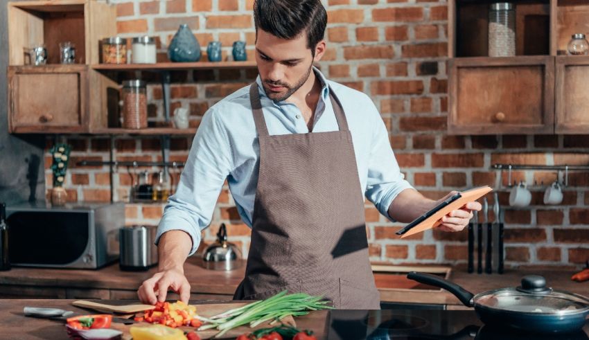 A man in an apron is preparing food in the kitchen.