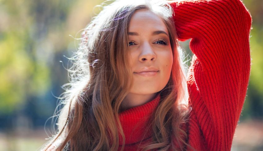 A woman in a red sweater is posing for a photo.