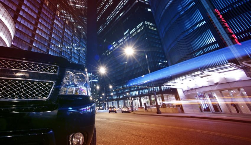 A black chevrolet tahoe parked on a city street at night.