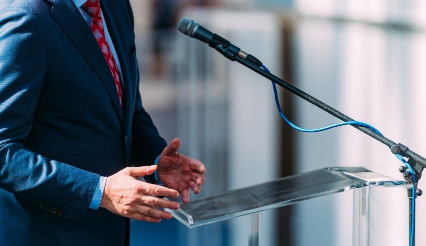 A man in a suit giving a speech at a podium.