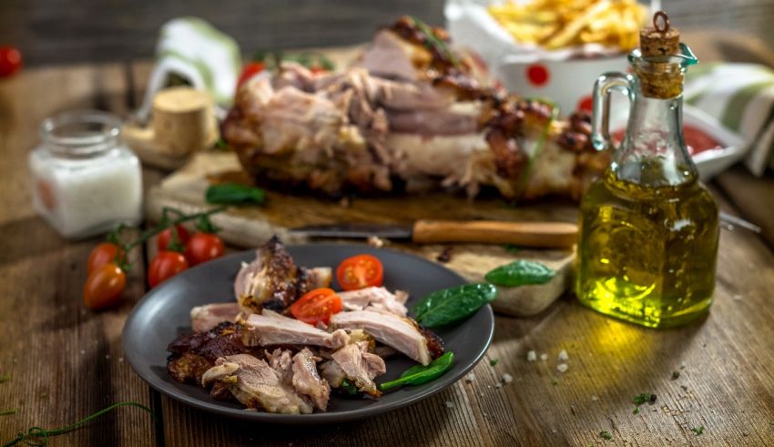 A plate of meat and vegetables on a wooden table.